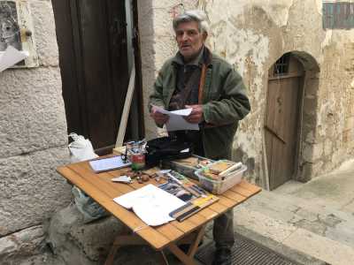 Qui, in un angolino situato all�ingresso di una corte medievale, si trova Angelo, con il suo banchetto pieno di oggetti inusuali